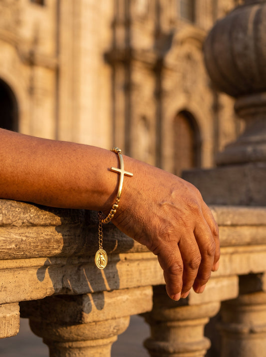 Brazalete rosario con cruz y Medalla Milagrosa en la muñeca al atardecer