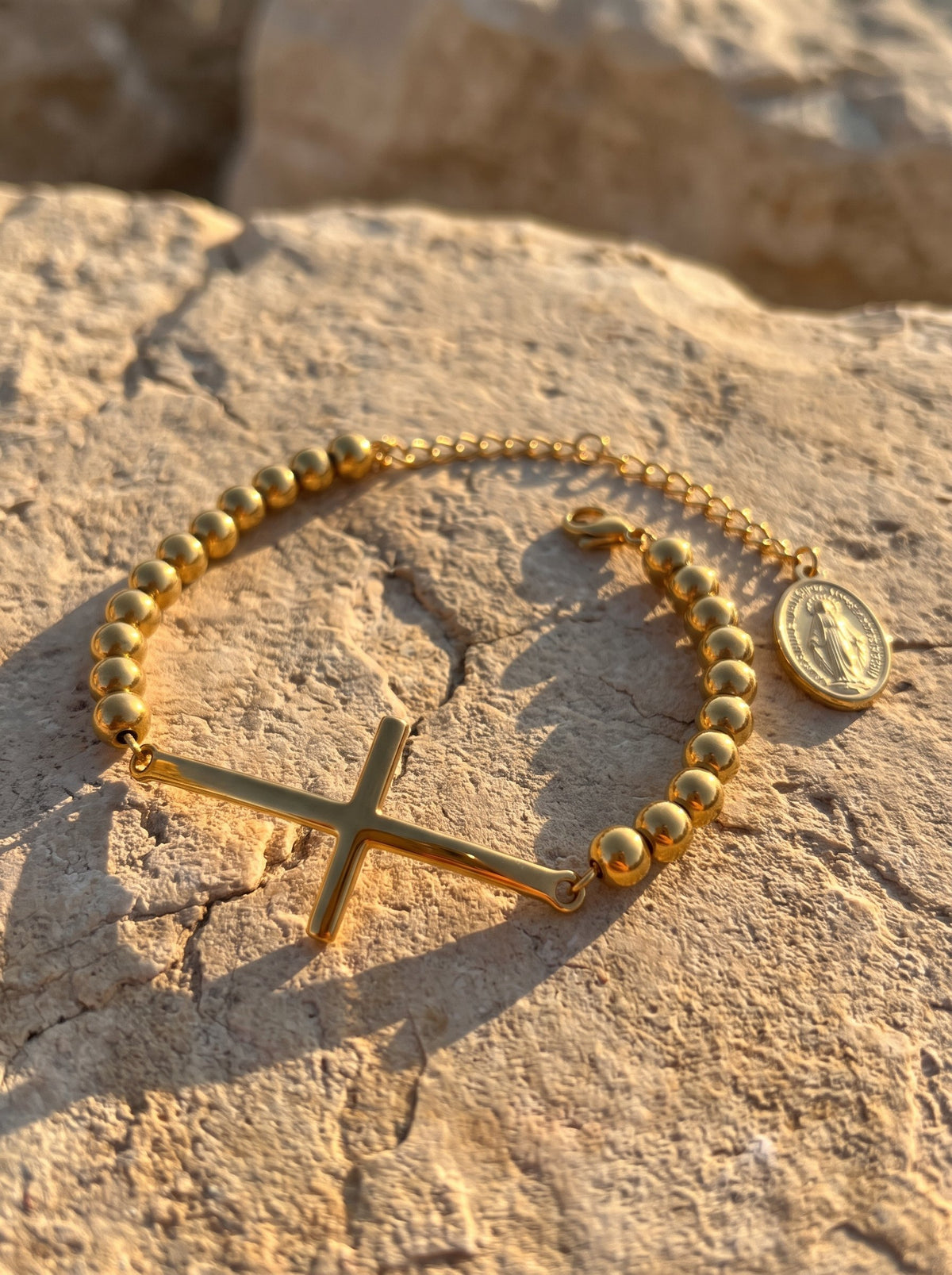 Brazalete rosario sobre piedra al atardecer